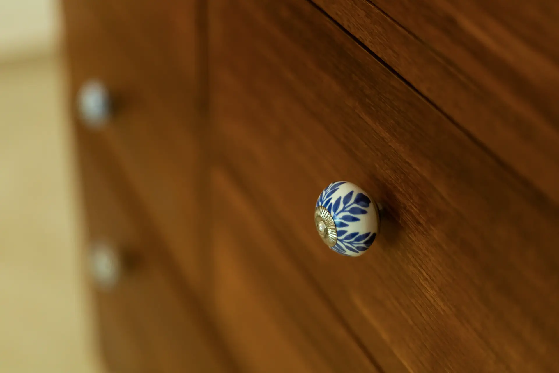 Teak chest of drawers with assorted ceramic knobs with blue prints